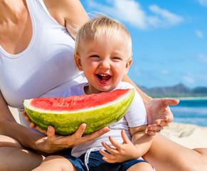 Mother and Son Enjoy Eating Delicious Ripe Watermelon on Beautiful Beach During Summertime