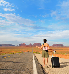 Woman  trying to hitch a ride on the roadside in Monyment Valley, Arizona-Utah border, USA