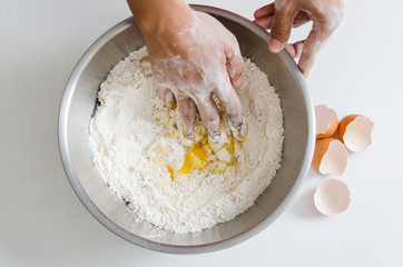 Bread cooking,hand mixing egg yolk,sugar and flour in a bowl.Homemade bakery at home
