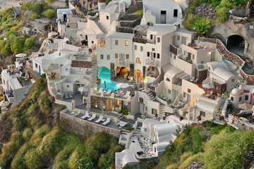 Fototapeta premium The famous Cycladic Architecture cave houses which are used as motels and inns built on cliffs in the town village of Oia, Santorini, Greece.