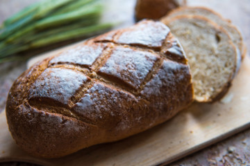 Bread slice on a wooden board. Wheat fresh loaf