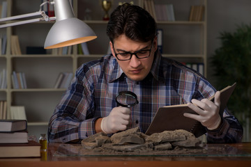 Archeologist working late night in office