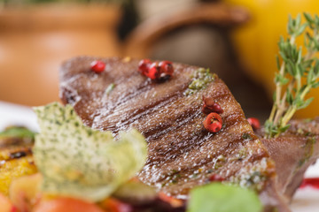 Beef tongue with rice and fruits on the grill. Close up.