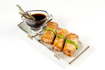 Three stuffed pancakes with soy sauce. Isolated on white background.