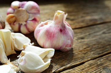 Clove of garlic and peeled on old wood background.