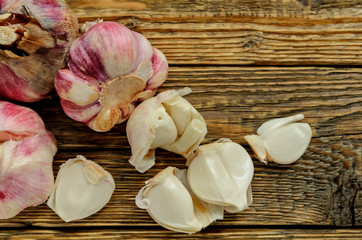 Clove of garlic and peeled on old wood background.