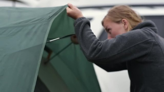 Young Woman Sets Up Rain Fly On Tent On Camping Trip In Pacific Northwest (Slow Motion)