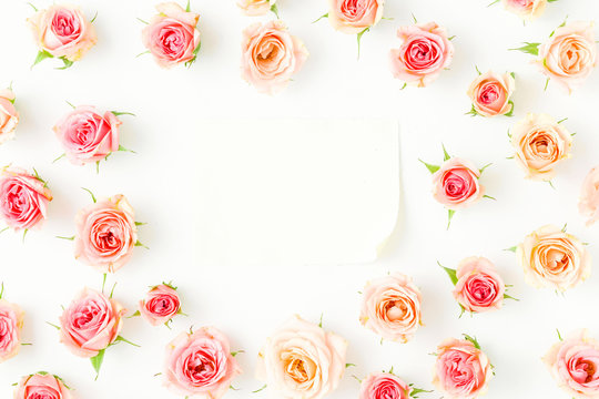 Frame of pink roses with sheet paper on white background