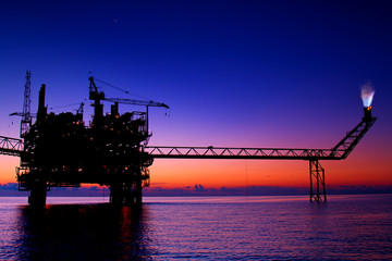 silhouette of an oil and gas offshore platform during sunset time