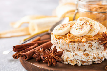Crisp bread with peanut butter and bananas on a board. Selective focus. Copy space