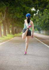 young fitness woman runner stretching legs before run