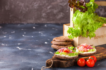 Sandwich with cheese, vegetables and red fish on a table. Healthy break. Selective focus. Copy space