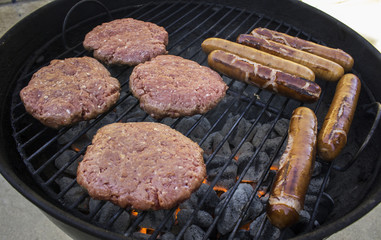 Hamburgers and hotdogs on the grill.