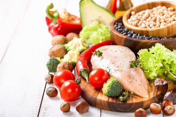 Raw chicken and fresh vegetables on a table. Healthy food. Selective focus. Copy space