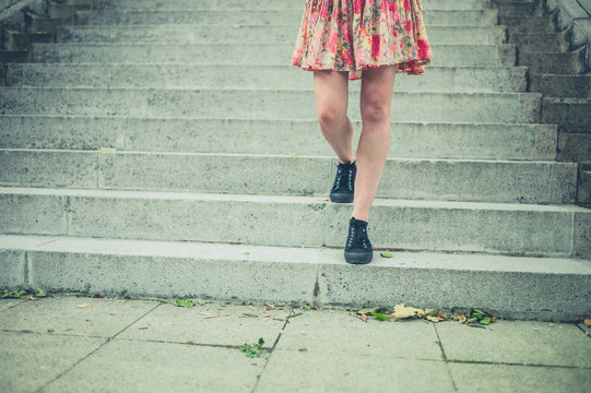 Legs of young woman walking down stairs in city