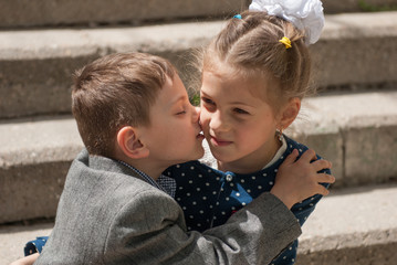 Fototapeta premium Little boy kissing an older girl