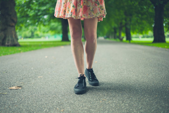 Legs of young woman walking in park
