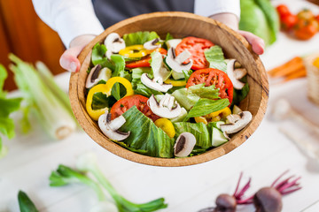 hands holding an healthy fresh vegetarian salad in a bowl