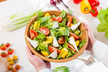 hands holding an healthy fresh vegetarian salad in a bowl