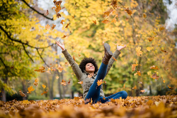 Autumn woman sitting with arms raised