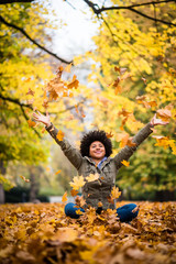 Happy woman in autumn park drop up leaves
