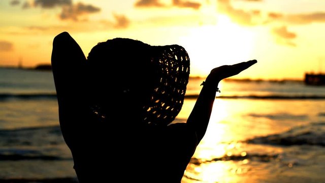 Silhouette of the woman enjoying the sunset, steadycam shot
