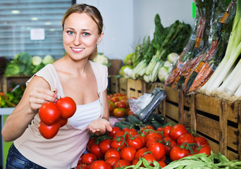 Portrait of  woman buying organic tomatoes in shop