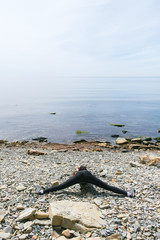 Girl practicing yoga on the rocks stands on a stone