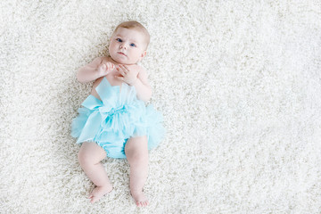 Adorable baby girl on white background wearing turquoise tutu skirt. © Irina Schmidt