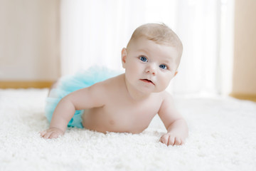 Adorable baby girl on white background wearing turquoise tutu skirt. © Irina Schmidt