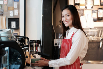Fototapeta na wymiar Young asian women Barista using coffee machine at counter in her cafe background, small business owner, food and drink industry concept