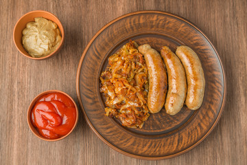 Grilled sausages with sauerkraut, mustard and tomato sauce. The view from the top.