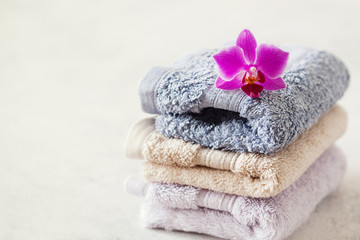 Bath towel set on wooden background with orchid
