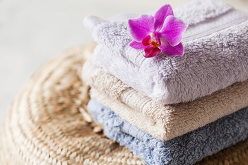 Bath towel set on wooden background with orchid