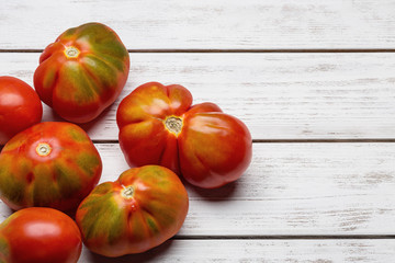 Tomatoes of unusual shape on white plates.