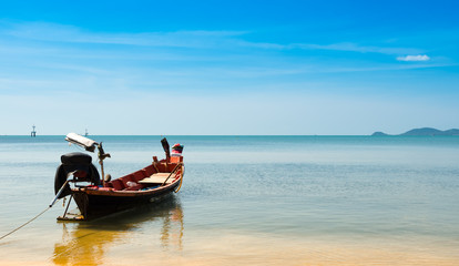 Fototapeta na wymiar wooden fising boat on blue sky and sea beach wiht copy space.