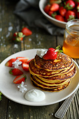 Golden pancakes with whipped cream and strawberry