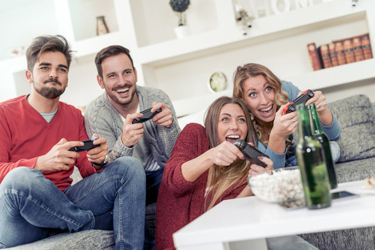 Young couples having fun playing video game at home.