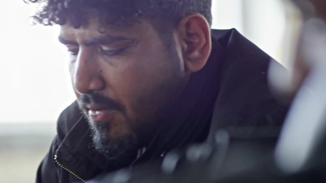 PAN with close up of sad Arab man with beard looking down and thinking about something