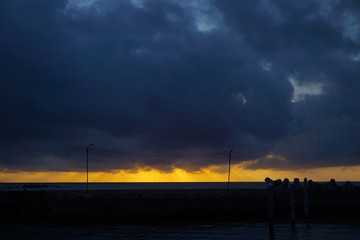 Silhouette of dock in the sea during sunset
