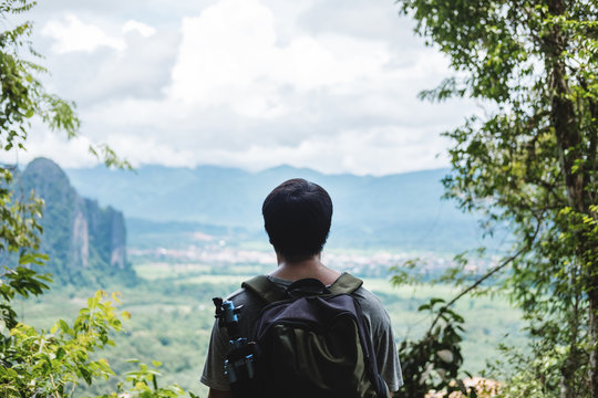 Young photographer with backpack enjoying beautiful landscaped nature view on the way to top of mountain in Laos, Traveling leisure activity hiking to sightseeing spot