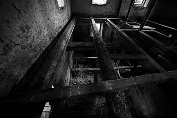 Destroyed burnt house with beams, inside, black and white photo