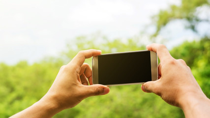Man holding a smartphone for taking a picture.