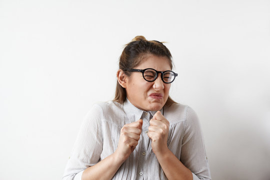 Stressed young European employee or office worker in glasses and shirt screwing her mouth in disgust, aversion or antipathy, gesturing with hands. Human emotions, feelings, attitude and reaction