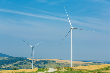 Fototapeta premium Wind turbines standing on a heels among fields