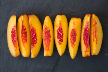 Juicy slices of fresh peach on slate