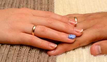Photo of hands with beautiful wedding rings on brown white background