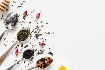 Variety of dried tea, dried herbal, green, black tea and fruit tea on vintage silverware tea spoons...