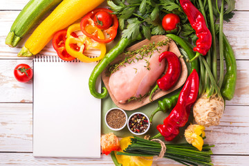 Raw chicken breast fillets with vegetables ingredients in pan