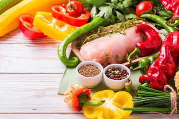 Raw chicken breast fillets with vegetables ingredients in pan